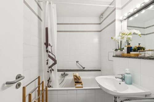 a white bathroom with a sink and a tub at Comfort Family & Business Apartment in Neunkirchen - 2 SZ - bis zu 5 Pers - Balkon - Badewanne - WLAN 250 Mbit - Parkplatz - Self-Check-in in Neunkirchen