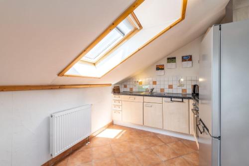 an attic kitchen with a skylight and a refrigerator at Appartement Kammblick in Gröbming