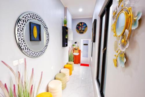 a hallway with yellow chairs and mirrors on the walls at The Tugu Residence in Sawah