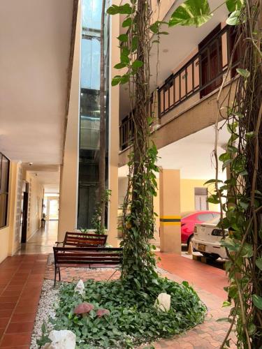 a courtyard with benches and plants in a building at Hotel San Francisco in Barranquilla