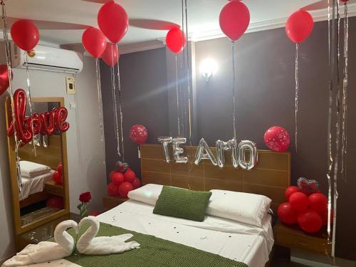 a bedroom with red balloons and a bed with a sign that reads train at Hotel San Francisco in Barranquilla