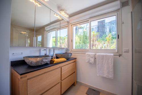 een badkamer met twee wastafels en een grote spiegel bij Villa Joia 2 vue mer 7 chambres in Saint-Tropez