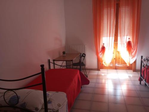 a bedroom with a bed and a table and a door at La casa di Titta in Faggiano