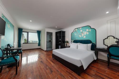 a bedroom with a bed and a table and chairs at Azen Lakeside Hotel & Travel in Hanoi