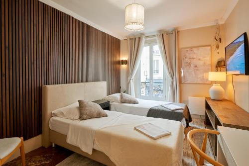 Charming Batignolles Studio في باريس: غرفة فندق بها سريران ومكتب