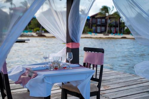 a table with wine glasses on a dock next to the water at X'tan Ha- The Waterfront in San Pedro