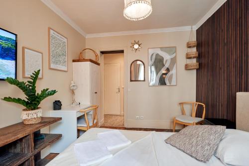 Charming Batignolles Studio في باريس: غرفة نوم بها سرير ومكتب ومطبخ