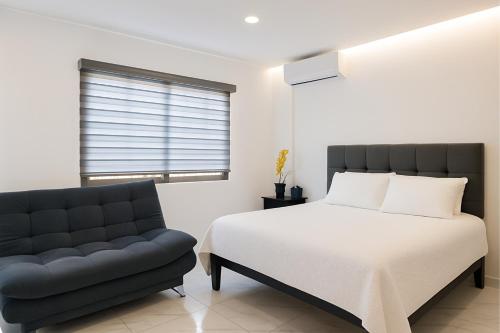 a bedroom with a bed and a couch at Sunset Suites Mazatlán at Lomas de Mazatlán in Mazatlán