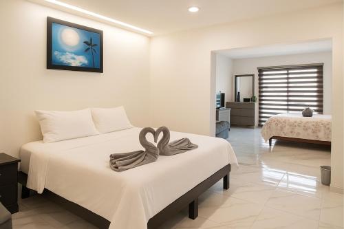a bedroom with a bed with a bow on it at Sunset Suites Mazatlán at Lomas de Mazatlán in Mazatlán