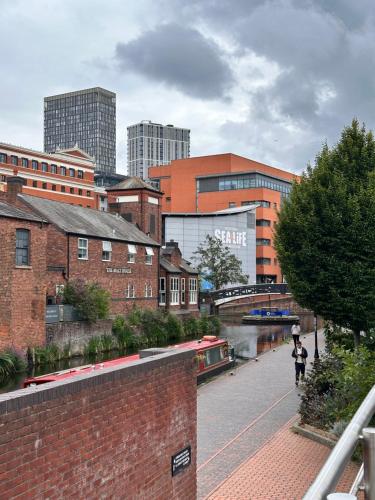 a person walking down a brick sidewalk in a city at Enjoy city living in this one-bedroom flat, complete with a balcony and secure parking in Birmingham city center in Birmingham