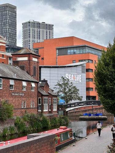 a city with buildings and a river with a boat at Enjoy city living in this one-bedroom flat, complete with a balcony and secure parking in Birmingham city center in Birmingham