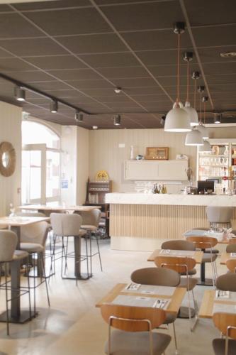 un restaurant avec des tables, des chaises et un comptoir dans l'établissement Hotel Ker Lehn - La Plage, à Piriac-sur-Mer