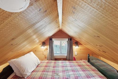 a bedroom with a bed in a wooden house at K1 Cottage in Greenville