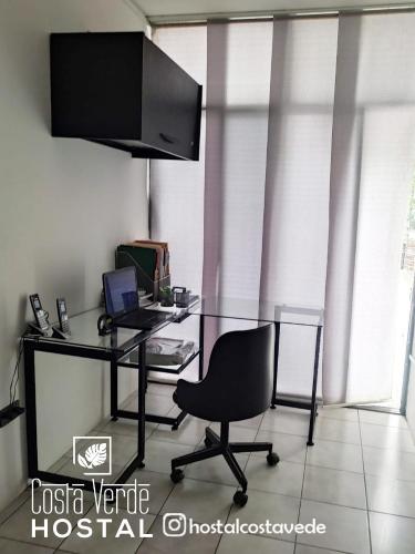 a desk with a laptop and a chair in a room at Costa Verde Hostal in Manta