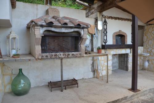 an outdoor fireplace with a bench and a vase at CASA VACANZE - LA CASINA DI LALLA - Greccio in Greccio