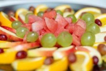 a plate of fruit salad with grapes and oranges at Hotel Klein Amsterdam in Friedrichstadt