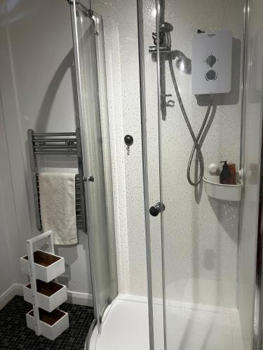 a shower with a glass door in a bathroom at 8b The Bookcase in Dawlish