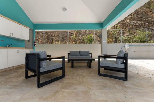 a living room with two chairs and a table at Villas at Chalet De Buye in Cabo Rojo