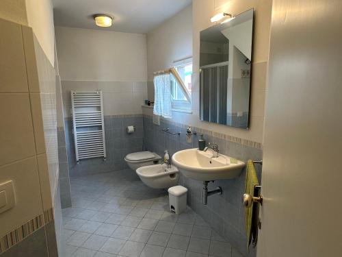 ein Badezimmer mit Waschbecken, Toilette und Spiegel in der Unterkunft Villa Alessandra in Forte dei Marmi