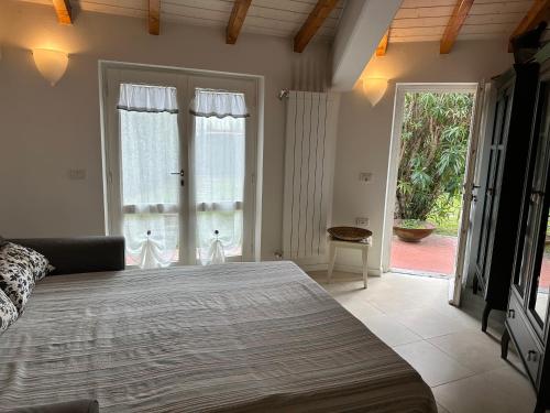 ein Schlafzimmer mit großem Bett und großen Fenstern in der Unterkunft Villa Alessandra in Forte dei Marmi