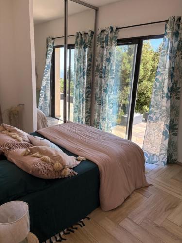 a bedroom with a bed and a large window at Chjama di mare in Santa-Maria-di-Lota