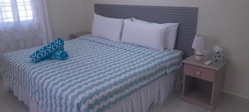 ein Schlafzimmer mit einem Bett mit einer blau-weißen Bettdecke in der Unterkunft Ocean Bliss Apt 6 in Christchurch