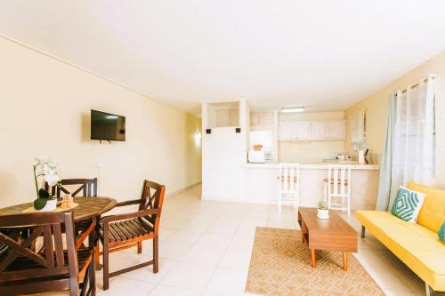 ein Wohnzimmer mit einem gelben Sofa und einem Tisch in der Unterkunft Ocean Bliss Apt 6 in Christchurch