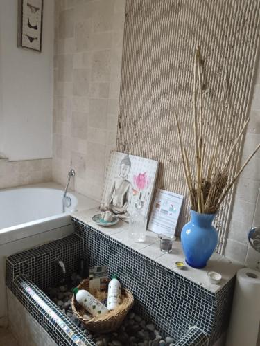 a bathroom with a bath tub with a basket and a vase at 3B Firenze in Capraia e Limite