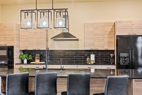 a kitchen with black counter tops and a black refrigerator at The Highlander - Luxe Hot Tub Firepit Views in Big Water