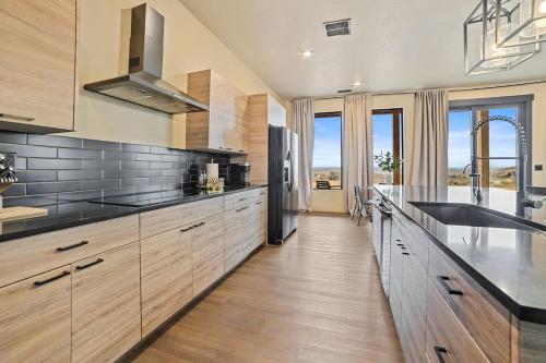 a kitchen with wooden cabinets and stainless steel appliances at The Highlander - Luxe Hot Tub Firepit Views in Big Water