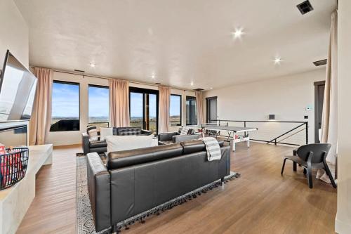 a large living room with couches and chairs and windows at The Highlander - Luxe Hot Tub Firepit Views in Big Water