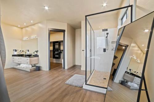 a large bathroom with a shower and a mirror at The Highlander - Luxe Hot Tub Firepit Views in Big Water