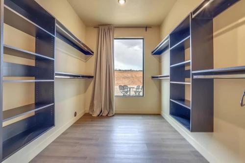 a walk in closet with blue shelves and a window at The Highlander - Luxe Hot Tub Firepit Views in Big Water