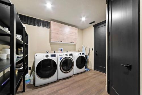 a laundry room with two washing machines in it at The Highlander - Luxe Hot Tub Firepit Views in Big Water