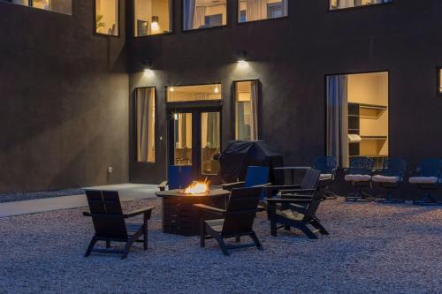a group of chairs and a table with a fire in front of a building at The Highlander - Luxe Hot Tub Firepit Views in Big Water