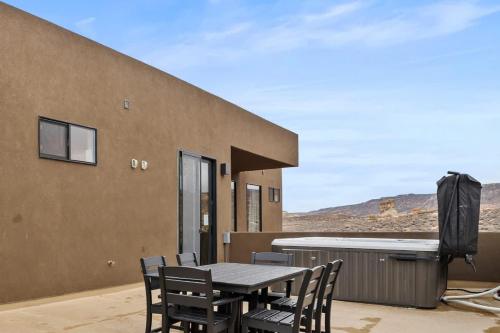 a table and chairs on the patio of a house at The Highlander - Luxe Hot Tub Firepit Views in Big Water