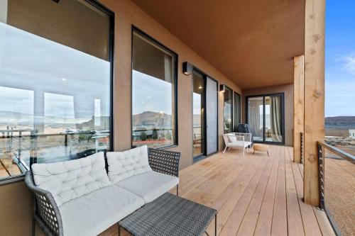 a living room with a white couch on a balcony at The Highlander - Luxe Hot Tub Firepit Views in Big Water