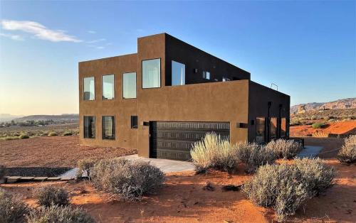 a house in the middle of the desert at The Highlander - Luxe Hot Tub Firepit Views in Big Water