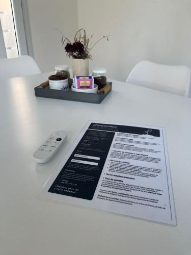 a menu on a table with a remote control at El Descanso Deseado in Puerto Deseado