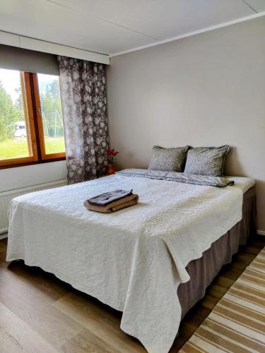 a bedroom with a bed with two towels on it at Rivitalokaksio, Kinnula in Kinnula