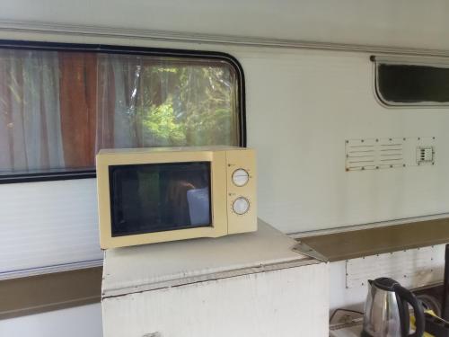 a microwave sitting on top of a window on a train at Бунгала Златна Рибка in Ahtopol