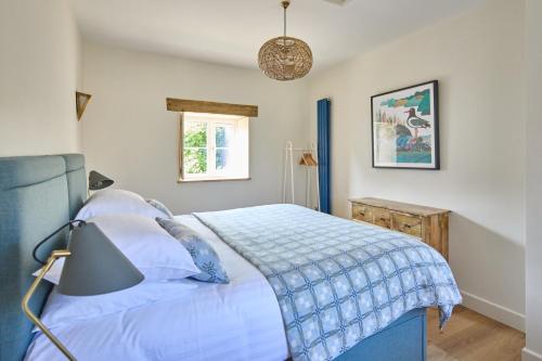 a bedroom with a bed with a blue blanket at Cwm Connell Coastal Cottages in Moylgrove