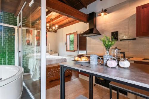 a kitchen with a sink and a bathroom with a tub at La Manzana in Candamo