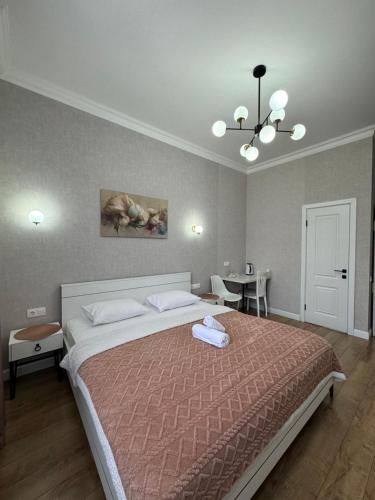a bedroom with a large bed and a dining room at Rose Art hotel in Astana