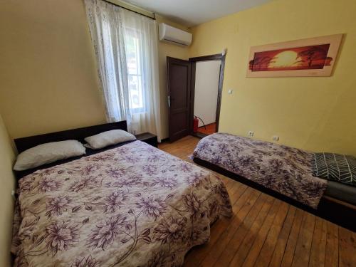 a bedroom with a bed and a window at Къщи за гости "Зелената долина" in Dalbok-Dol