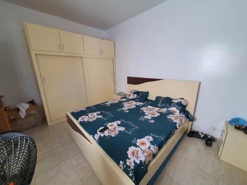 ein Schlafzimmer mit einem Bett mit einer blauen Bettdecke in der Unterkunft Sicap baobab , Mermoz, Sacré Coeur , Clim, Wifi, Balcon, Dakar in Grand Dakar