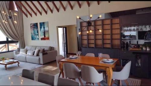 Una sala de estar con una mesa y sillas de madera. en Casa do Vinho no Altos da Serra, en Bom Jardim da Serra