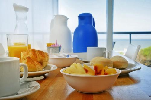 een tafel met borden en kopjes sinaasappelsap bij PROA Playa in Villa Gesell