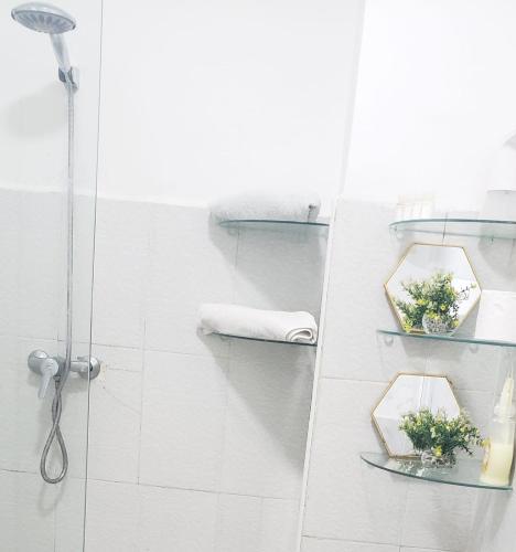 a bathroom with a shower with two glass shelves at Sweet Home in El Jadida