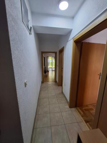 un corridoio che conduce a una stanza con una porta e un pavimento piastrellato di Ana Apartment a Ohrid